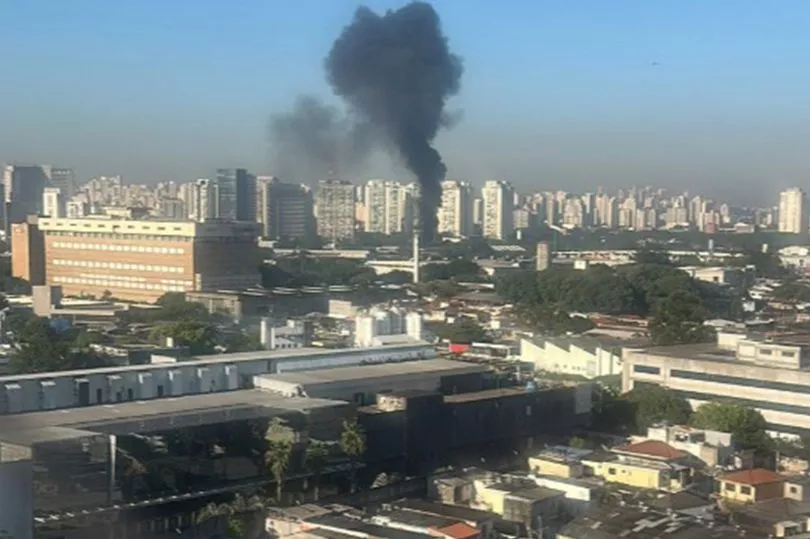 Plane crashes into bus in middle of city with plumes of smoke leaving two dead